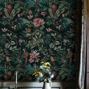 May include: Dark green wallpaper with a jungle theme, featuring monkeys, birds, and pink flowers. The design includes lush foliage and a variety of tropical elements, creating a vibrant and detailed pattern. A table with a vase of flowers and a candle holder is in the foreground.