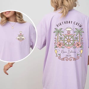 May include: A light purple t-shirt with a nautical-themed graphic on the front and back. The front features an anchor design with the name "Emily". The back displays "BIRTHDAY CREW" with a ship's wheel, palm trees, and the text "Nassau Bahamas 2025".