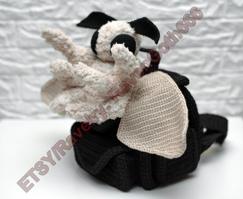 May include: A handmade black and white crochet creature with outstretched arms. The creature has a black body, head, and ears, with off-white arms and face. The image includes the text "ETSY/RavenGoth666".