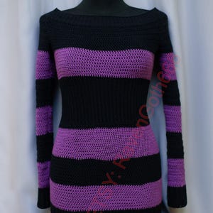 Pode incluir: Um vestido de camisola de croch&ecirc; listrado preto e roxo. O vestido de manga comprida apresenta listras horizontais pretas e roxas. O decote &eacute; um decote largo em barco.