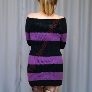 Pode incluir: Um vestido de croch&ecirc; listrado em preto e roxo, com ombros de fora. O vestido apresenta listras horizontais alternadas em preto e roxo. A parte superior tem um design semelhante a uma malha. O vestido &eacute; justo e parece ser feito &agrave; m&atilde;o.