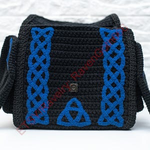 May include: Black crochet bag with blue Celtic knotwork design. The bag features a flap closure and side panels. The blue knotwork is on the front and sides of the bag. The bag is sitting on a white surface.
