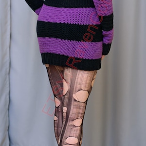 Pode incluir: Um vestido de croch&ecirc; listrado em preto e roxo, com ombros de fora. O vestido &eacute; combinado com meias pretas rasgadas e saltos altos pretos com plataforma. A roupa &eacute; uma declara&ccedil;&atilde;o de moda ousada.