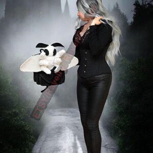 May include: A crochet moth plushie in black and white, with large wings. The moth is held by a person in a black outfit. The background shows a misty forest and a castle silhouette.