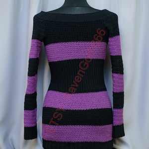 Pode incluir: Vestido de croch&ecirc; listrado preto e roxo com mangas compridas. O vestido apresenta um decote canoa e listras horizontais em preto e roxo. O vestido &eacute; exibido em um manequim preto.