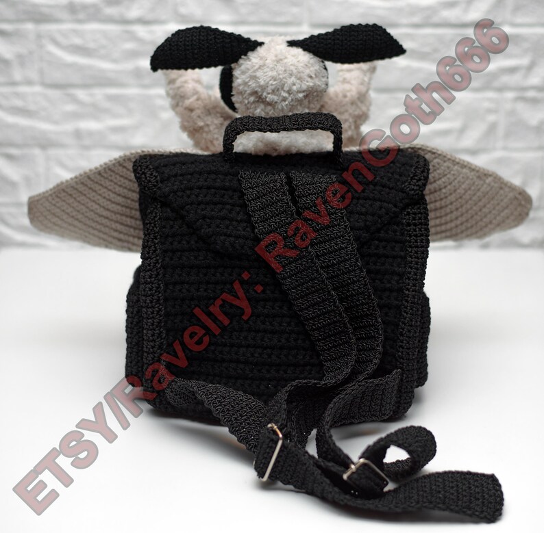 May include: A black crochet backpack with adjustable straps and a top handle. The backpack features a plush, light-coloured head with black ears and grey wings. The text "ETSY/Ravelry: Ravencoth666" is visible.