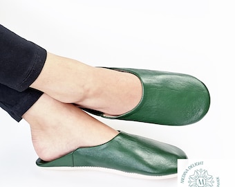 May include: A pair of green leather slippers with a white sole. The slippers are made of soft leather and have a comfortable fit.