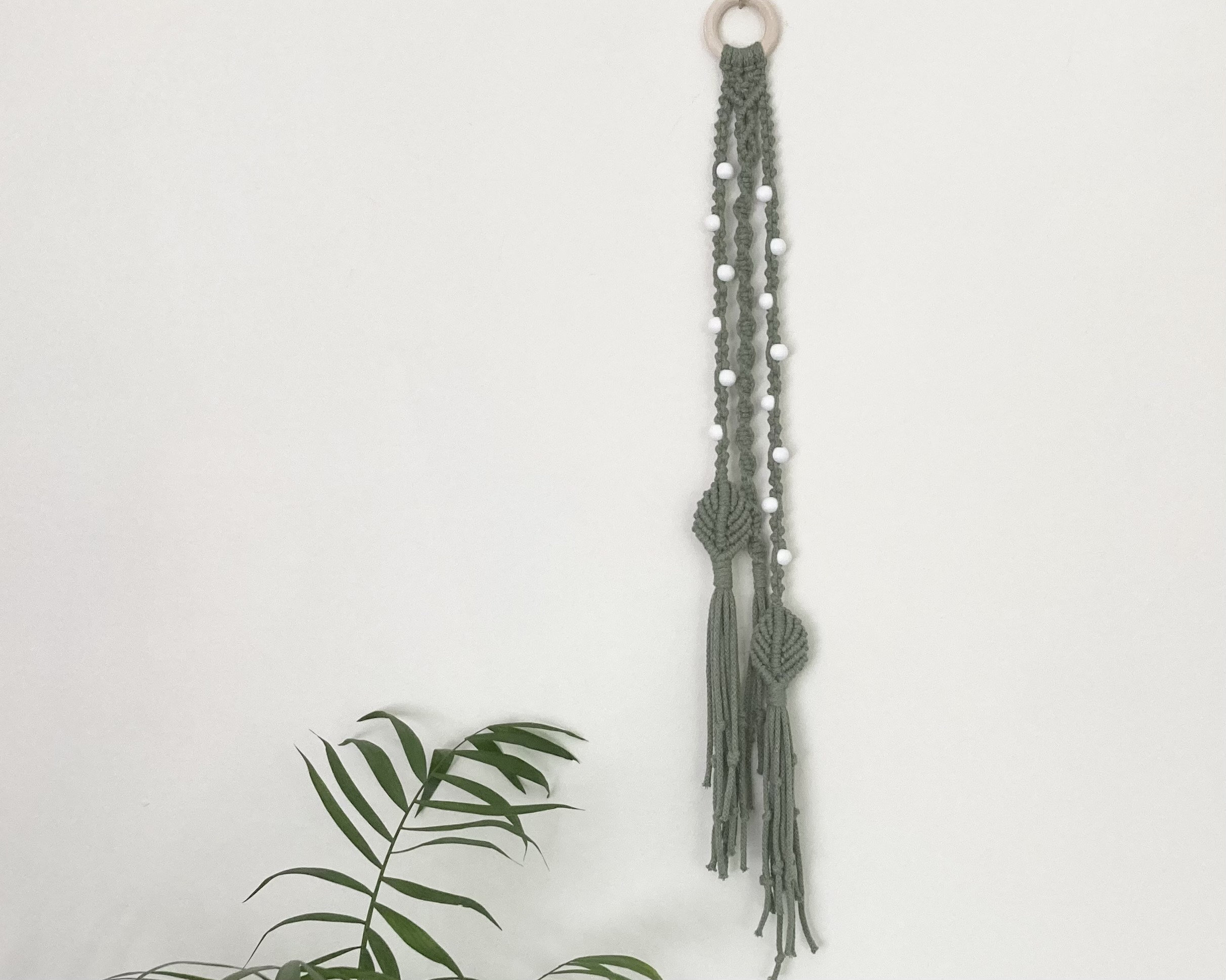 Macrame hanging decoration in green braided cord, boho, hippy, beaded decor.
