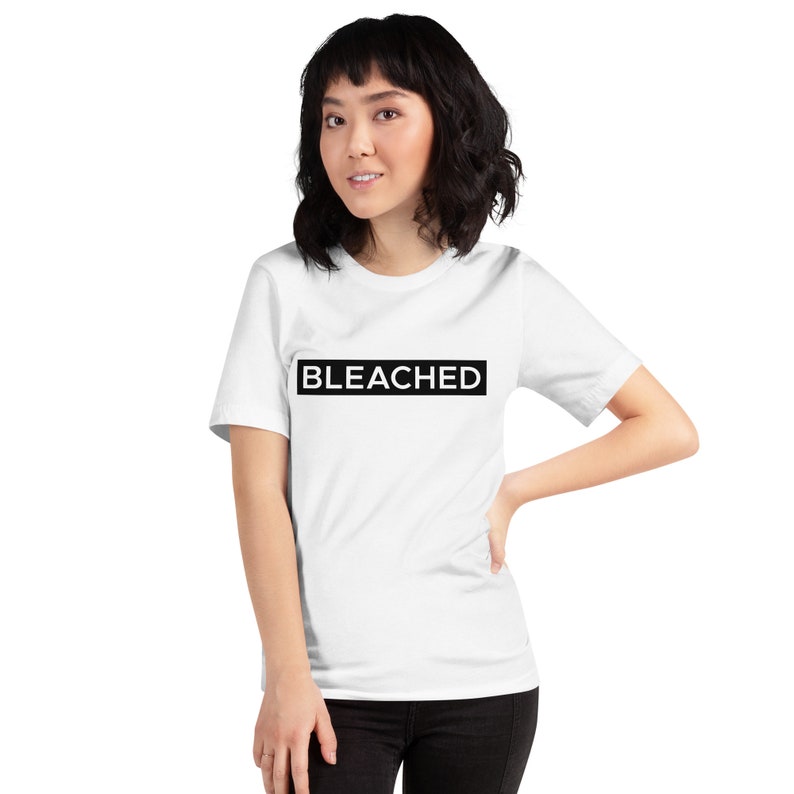 K&ouml;nnte beinhalten: Ein wei&szlig;es T-Shirt mit einem schwarzen Rechteck, auf dem in wei&szlig;en Buchstaben "BLEACHED" steht.
