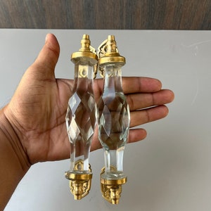 May include: Two clear glass door knobs with faceted designs and gold metal bases.