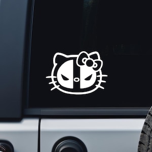 May include: A black and white vinyl decal of a Hello Kitty character with a Deadpool mask. The decal is on a black car.