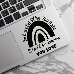 以下が含まれることがあります： 虹のデザインと「Be Careful Who You Hate It Could Be Someone You Love」というテキストが書かれた白黒のステッカーです。