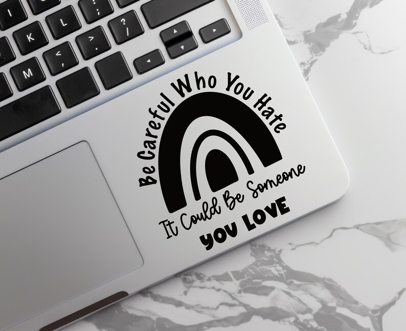 以下が含まれることがあります： 虹のデザインと「Be Careful Who You Hate It Could Be Someone You Love」というテキストが書かれた白黒のステッカーです。