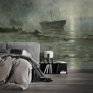 May include: A wall mural featuring a dark, moody seascape with two weathered wooden boats anchored in shallow, rocky water under a hazy, moonlit sky. The scene is rendered in muted shades of green, gray, and brown, creating a textured, atmospheric effect.