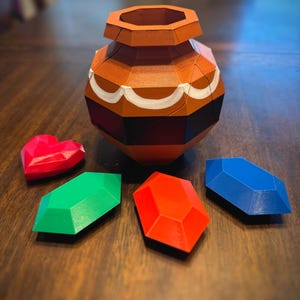 May include: A brown, octagonal, ceramic pot with white accents sits on a wooden surface. Four colorful, geometric shapes, resembling gems, are scattered around the pot. The gems are red, green, blue, and orange.