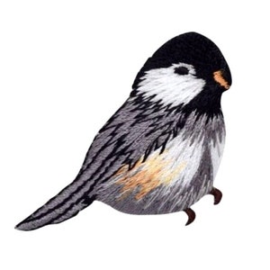 May include: Embroidered iron-on patch of a gray and black bird with a white chest and a yellow beak.