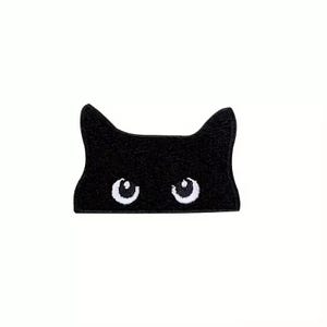 May include: Black felt cat face patch with embroidered white eyes.