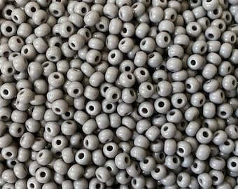 Könnte beinhalten: Nahaufnahme einer großen Menge kleiner, runder, grauer Perlen. Die Perlen sind aus Keramik und haben eine glatte, glänzende Oberfläche.