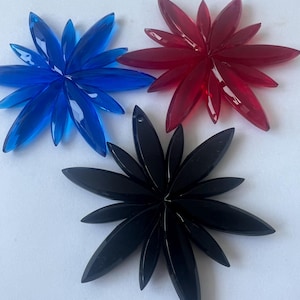 以下が含まれることがあります： 青、赤、黒の装飾的なクリスタルスターバースト形状3つ