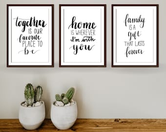 May include: Three framed prints with black calligraphy on a white background. The first print says "together is our favorite place to be". The second print says "home is wherever I'm with you". The third print says "family is a gift that lasts forever".