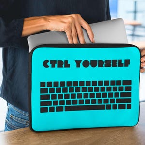 May include: A bright blue laptop sleeve with a black keyboard graphic and the text "CTRL YOURSELF" in black.