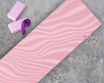 May include: A pink yoga mat with a wavy pattern, two pink yoga blocks, a purple yoga strap, and a beaded necklace.