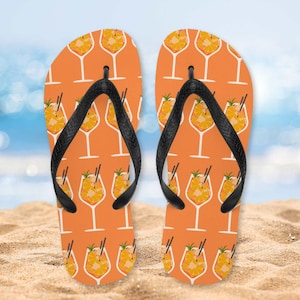 May include: A pair of orange flip flops with a black strap and a repeating pattern of orange slices in a glass.
