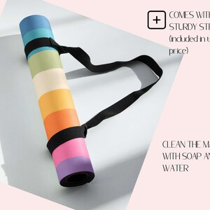 May include: A rolled-up yoga mat with a rainbow pattern and a black carrying strap. The text "COMES WITH A STURDY STRAP (induded in the price)" is visible in the upper right corner. The text "CLEAN THE MAT WITH SOAP AND WATER" is visible in the lower right corner.