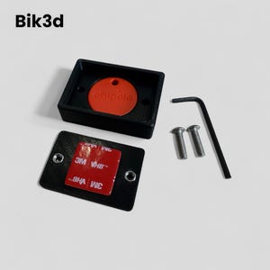 May include: A black plastic box with a red round chip inside. The box has two screws and a small Allen wrench. The box also has a 3M adhesive strip on the back.