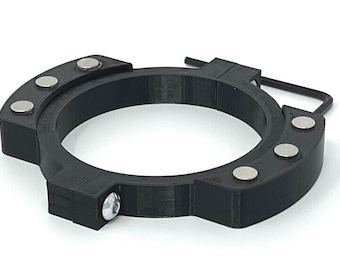 May include: Black plastic ring with five silver magnets and a small screw. The ring is designed to hold objects in place.