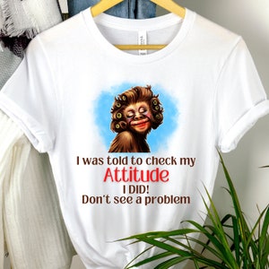 May include: White t-shirt with a cartoon image of a monkey with makeup and the text "I was told to check my Attitude I DID! Don't see a problem."