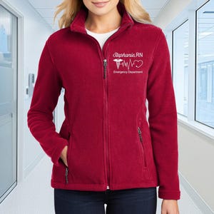 a woman in a red jacket standing in a hallway