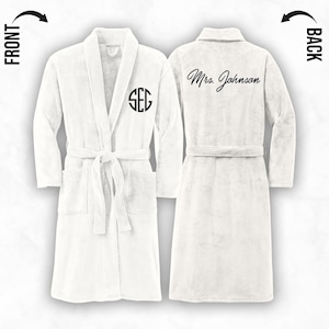 May include: White bathrobe with a monogram on the left side and the text "Mrs. Johnson" on the back.
