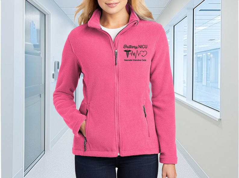 a woman in a pink jacket standing in a hallway