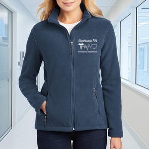 a woman in a blue jacket standing in a hallway