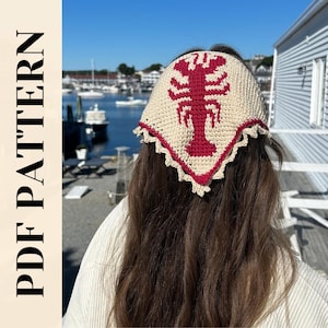 Peut inclure: Un foulard au crochet de couleur crème avec un motif de homard rouge. Le foulard a une bordure rouge festonnée. Les mots "PDF PATTERN" sont imprimés verticalement sur le côté gauche de l'image.