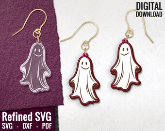 May include: A pair of ghost-shaped earrings with a smiling face. The earrings are made of white and brown wood and have gold hooks. The earrings are on a white background.