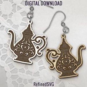 May include: A pair of wooden earrings shaped like ornate teapots with intricate floral designs. The earrings are brown with a light wood grain and have silver hooks.
