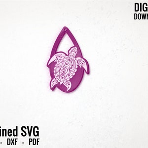 May include: A pink teardrop-shaped earring with a white detailed turtle design.