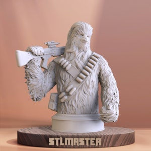May include: A white 3D printed bust of Chewbacca from Star Wars, holding a blaster rifle. The bust is on a wooden base with the text "STLMASTER" printed on it.