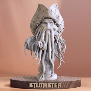 May include: A detailed bust of a pirate with a hat, tentacles, and a pipe. The sculpture is light gray and sits on a wooden base. The text "STLMASTER" is visible on the base.