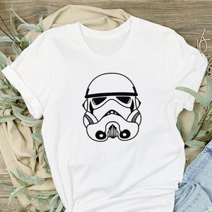 May include: White t-shirt with a black outline of a Star Wars Stormtrooper helmet.