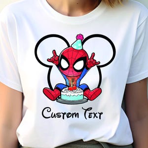 May include: White t-shirt with a cartoon Spider-Man design, wearing a party hat and holding a birthday cake. The design is framed by a Mickey Mouse-style outline, with the words "Custom Text" beneath the image.