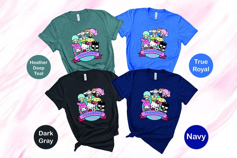 May include: Four t-shirts in different colors with a graphic print of cartoon characters. The characters are wearing hats and holding a soccer ball. The text "Friendship Goals" is printed on the shirts. The colors of the shirts are heather deep teal, true royal, dark gray, and navy.