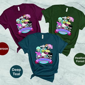 May include: Three t-shirts in maroon, deep teal, and heather forest colors. Each shirt features a graphic print of cartoon characters with the text "Friendship Goals".
