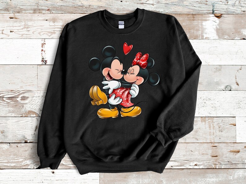 May include: Black sweatshirt with a graphic of Mickey Mouse and Minnie Mouse hugging with a red heart above them.