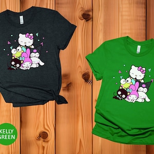 Pu&ograve; includere: Due t-shirt con una stampa grafica di Hello Kitty e i suoi amici. La t-shirt a sinistra &egrave; grigio scuro melange e la t-shirt a destra &egrave; verde Kelly.