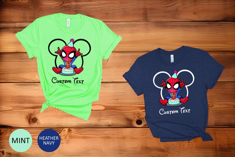 May include: Two short-sleeved t-shirts, one mint green and one navy blue, with a cartoon Spider-Man design and a birthday cake. The design includes a Mickey Mouse head outline and the text "Custom Text".