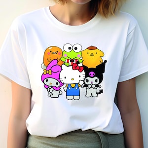 May include: White t-shirt featuring a graphic print of popular cartoon characters, including Hello Kitty, Keroppi, My Melody, and Tuxedo Sam.