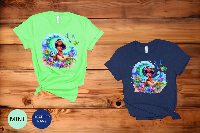 Peut inclure: Deux t-shirts avec une illustration color&eacute;e d'un personnage de dessin anim&eacute; sur une vague. Le personnage porte un collier de fleurs et a de longs cheveux bruns. Les t-shirts sont disponibles en vert menthe et bleu marine chin&eacute;.